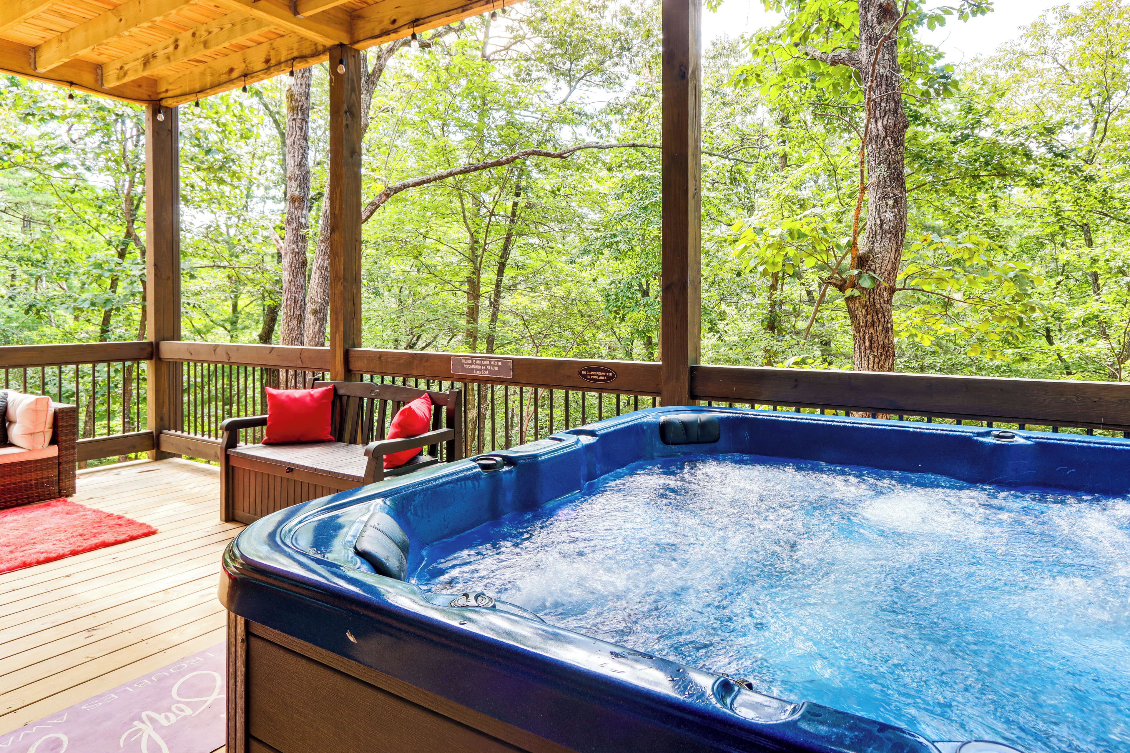 Ein Whirlpool auf einer Holzterrasse mit Blick auf Bäume.