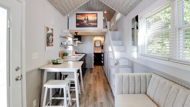 A modern kitchen with a wooden ceiling, a dining area with stools, and a seating area with a bench. - The Merlot Bungalow Defiance Tiny Home on Trail (Defiance)