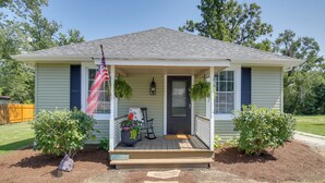 A single-story house with a front porch, a small garden, and a flag. - 'the Cabernet Cabin' Defiance Home on Katy Trail! (Defiance)