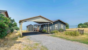 A two-story house with a covered driveway and a view of a lake. - Lakefront Chiloquin Home w/ Scenic Deck! (Chiloquin)