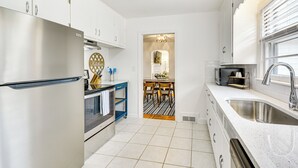 A modern kitchen with stainless steel appliances, a blue cart, and a large sink. - 'dogwood Cottage' w/ Fireplace: 1 Mi to University (High Point)