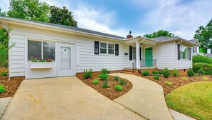 A single-story house with a front porch, a green door, and a small garden area with various plants. - 'dogwood Cottage' w/ Fireplace: 1 Mi to University (High Point)