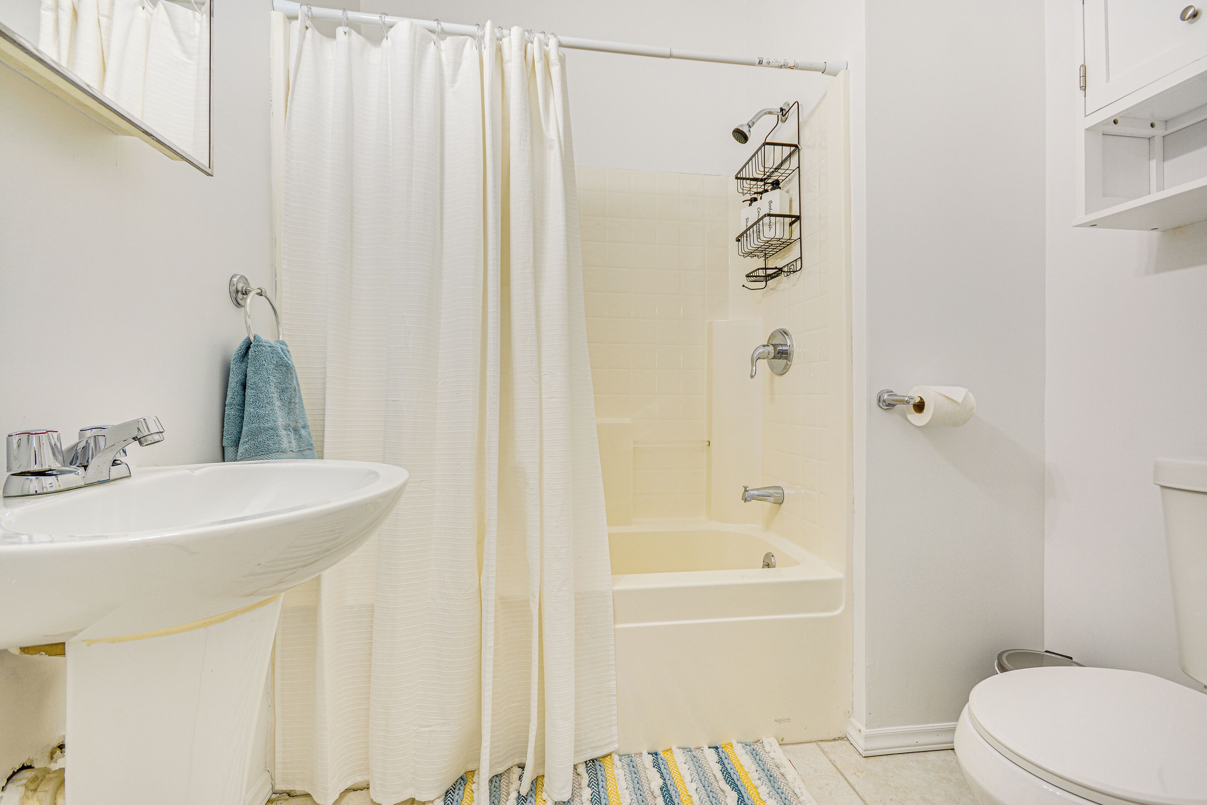 A bathroom with a white sink, a bathtub, and a toilet.
