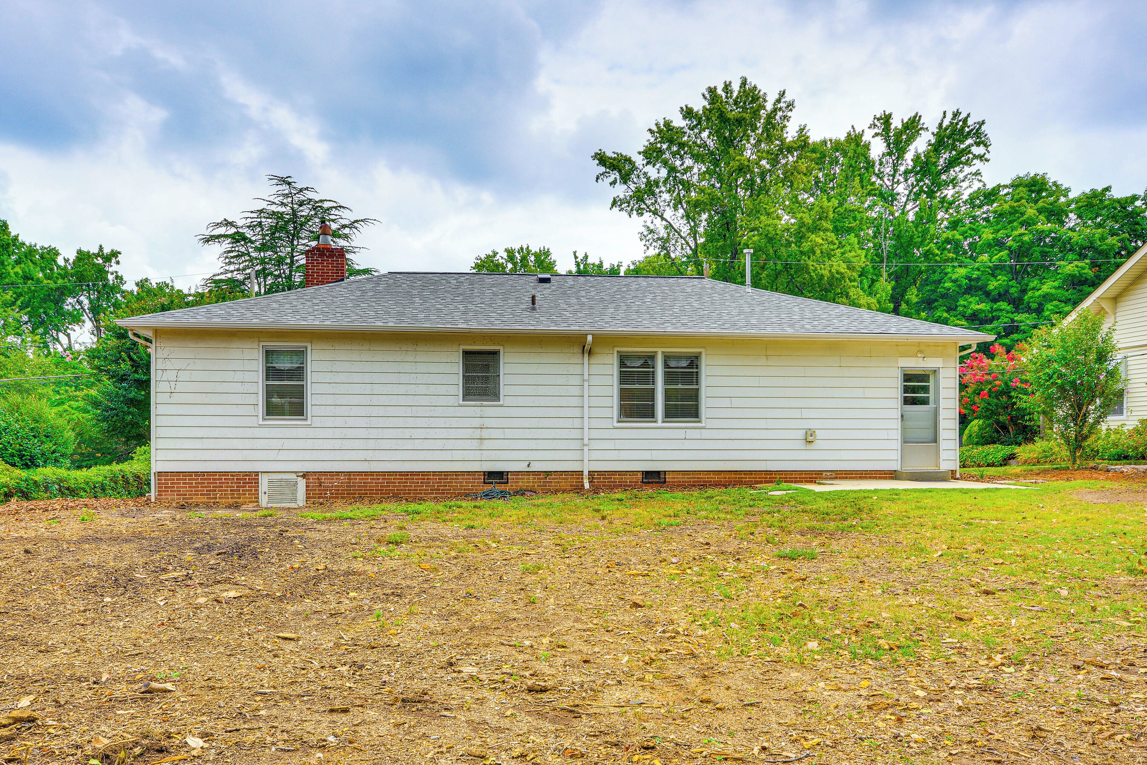 A single-story house with a brick foundation and a sloped roof.