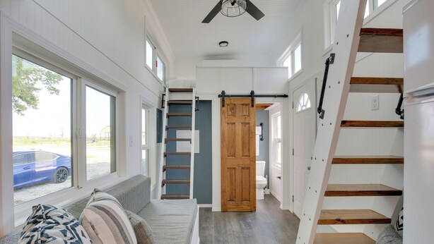 A narrow hallway with a wooden staircase, a sliding door, and a view of a blue car outside. - 'the Chardonnay Chalet' Defiance Studio Trail! (Defiance)