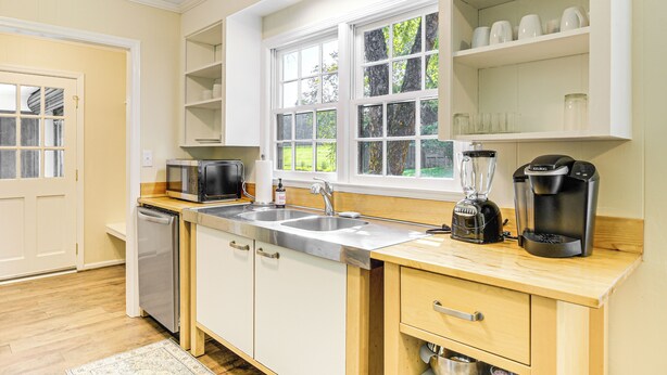 Una cocina moderna equipada con lavavajillas, microondas, pileta y cafetera.