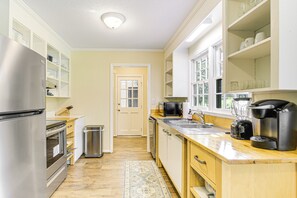 A modern kitchen with stainless steel appliances, wooden cabinets, and a large window. - Fire Pit & Views: Campobello Rural Retreat (Campobello)