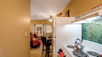 A kitchen with a stove, oven, and a dining area with a table and chairs.
