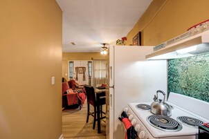 Una cocina con estufa, horno y un comedor con mesa y sillas.