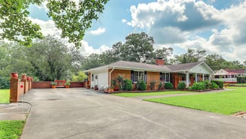 A two-story house with a front porch, brick exterior, and a well-maintained lawn.