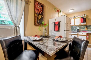 A dining area with a marble table, black leather chairs, a refrigerator, and a kitchen counter with cabinets. - Charming Studio ~ 5 Mi to Stone Mountain Park (Stone Mountain)