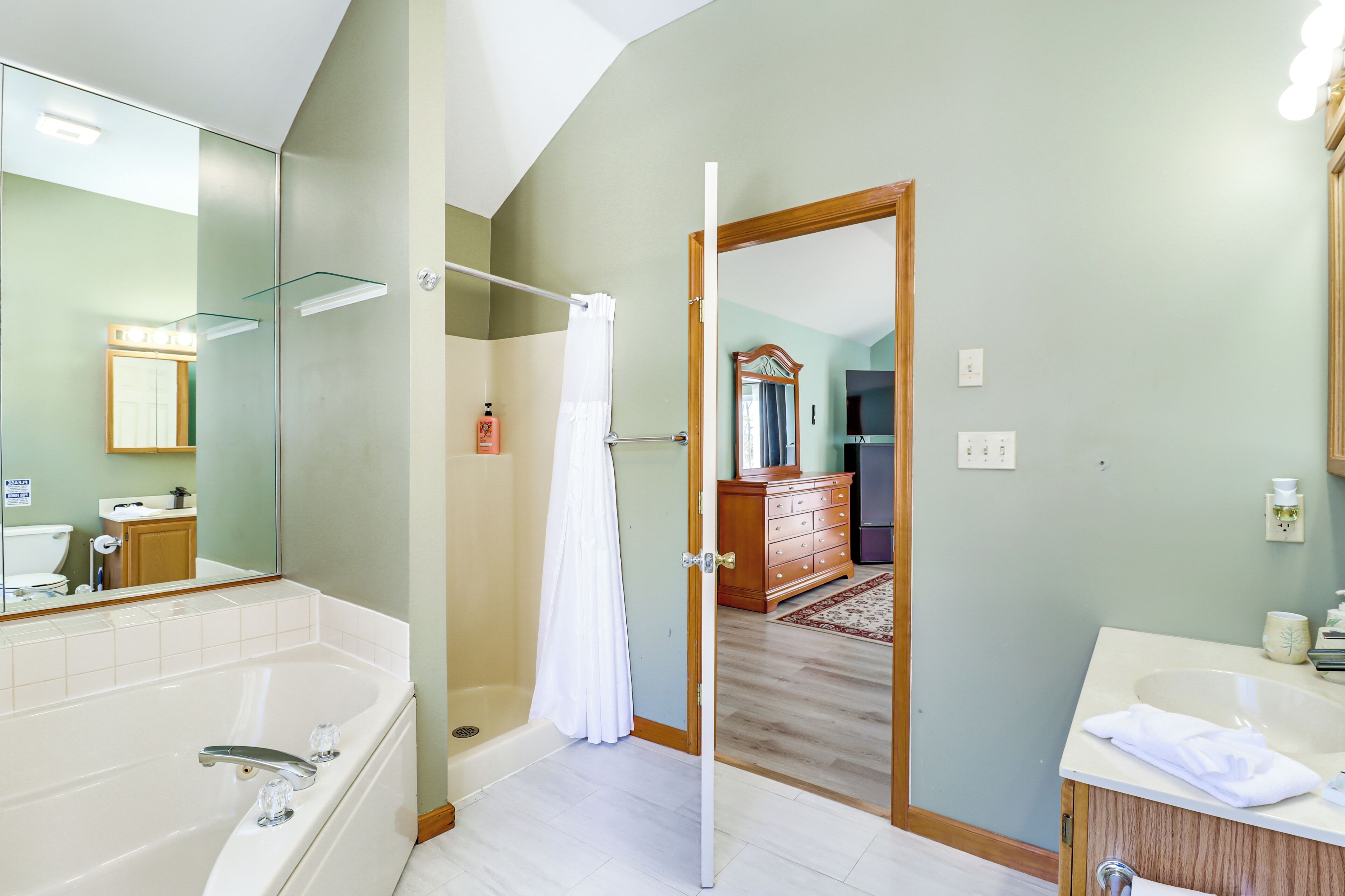 Un baño moderno con bañera, ducha y tocador con lavabo.
