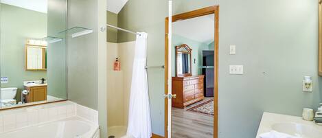 Un baño moderno con bañera, ducha y tocador con lavabo.