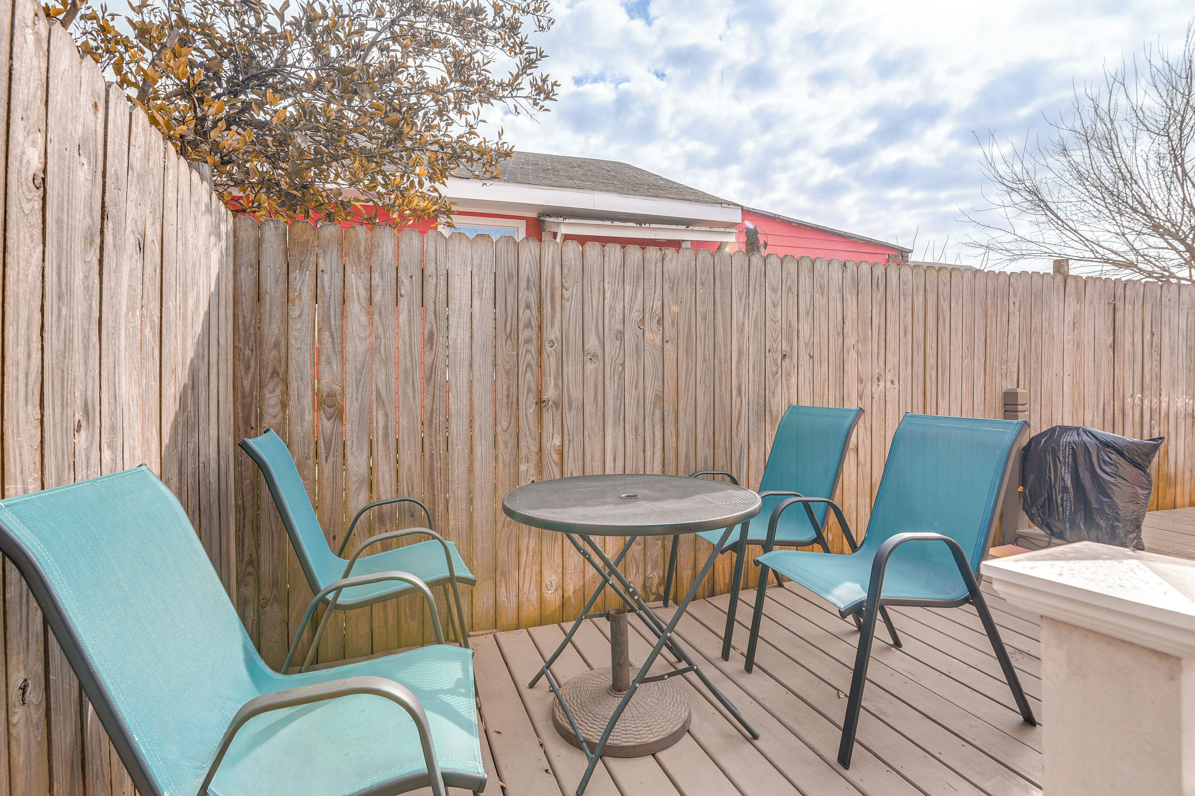 A wooden deck with a round table and four chairs.