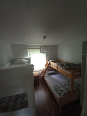 A small, single-room accommodation with a bunk bed, a desk, and a window with curtains. - Arctic Paradise - 4 Bedroom Apartment in Tromso (Tromsø)