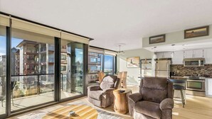 Een modern appartement met balkon, keuken en woonkamer met banken en een salontafel.