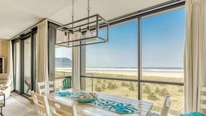 Comedor con una mesa dispuesta para dos, con vista a la playa.