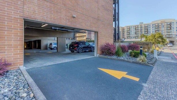 Een parkeergarage-ingang met een zwarte SUV erin.