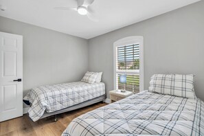 A bedroom with two beds, a window with blinds, a ceiling fan, and a nightstand with a lamp. - Pet-Friendly Home 4 Miles to Beach & Shops (Naples)