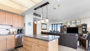 Una cocina moderna con armarios de madera, una isla integrada e iluminación colgante.