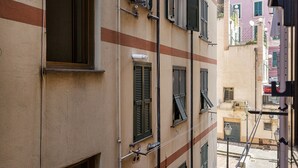 Une rue étroite bordée d’immeubles dotés de nombreuses fenêtres et de volets.