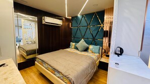 Un dormitorio moderno con cama, piso de madera y un cabecero decorativo.