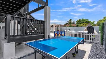 Enjoy a game of ping pong on the patio, surrounded by lush greenery and a serene view.