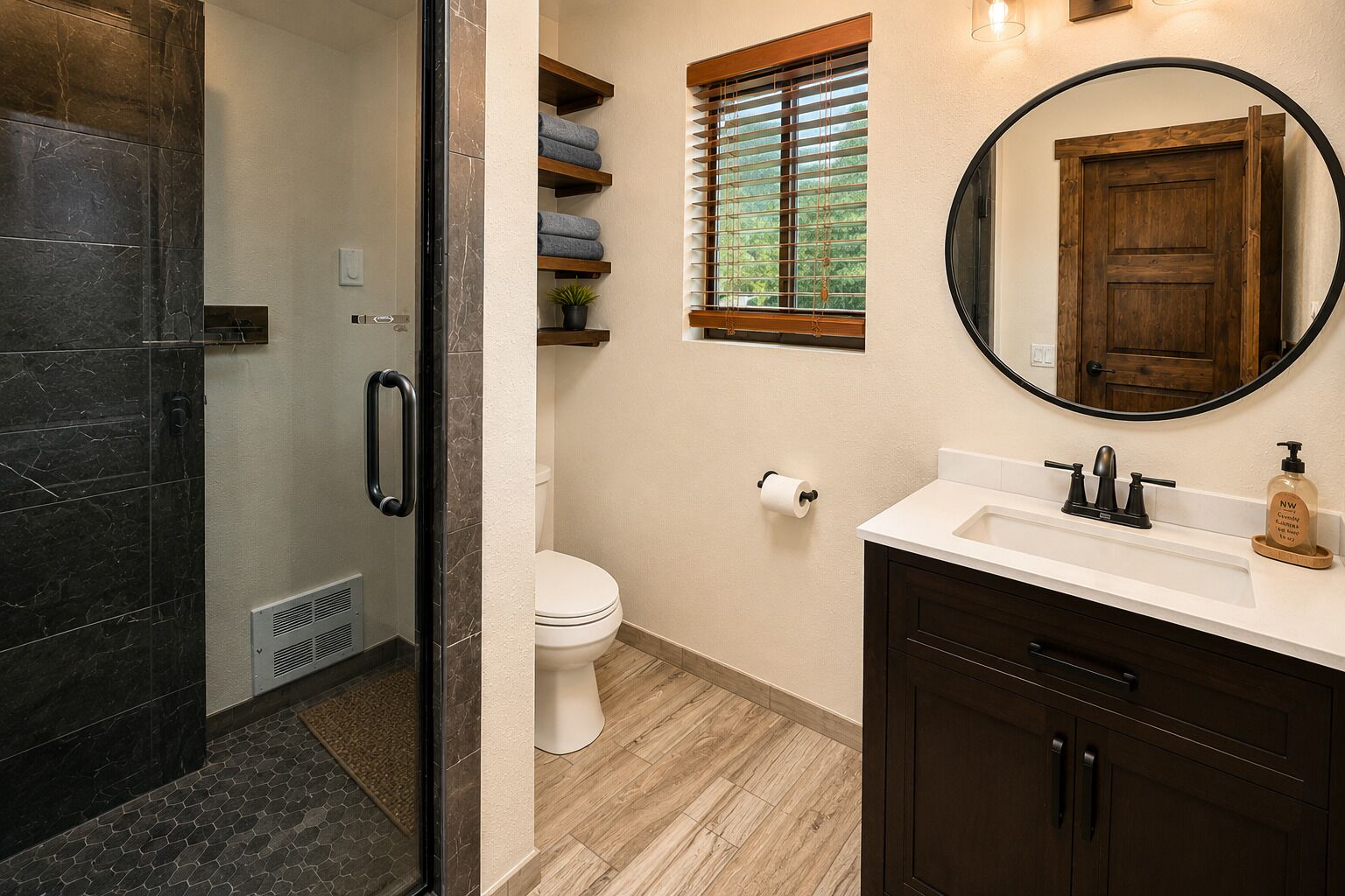 Une salle de bain équipée d’une douche, de toilettes, d’un meuble-lavabo et d’un miroir.