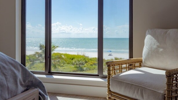 Una habitación con un ventanal grande que ofrece vistas a la playa y al océano.