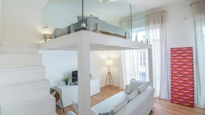 Une chambre de style loft moderne avec un plafond en verre, un lit, un bureau et un rideau rouge à motifs.