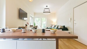 Una cocina moderna con encimera de madera, horno empotrado y televisor de pantalla plana montado en la pared.