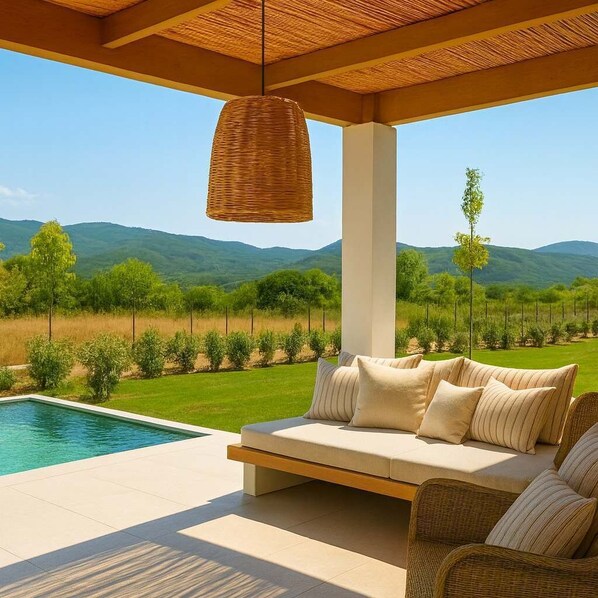 A modern outdoor seating area with a pool, overlooking a lush landscape with mountains. - Aristotelia Gi Domes - Luxury Private Pool Retreat (Olympiada)