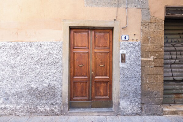 A double wooden door with a brass handle, set in a stone wall with a number '4' sign above it. - Ramaglianti Hidden Gem by Mmega (Florence)