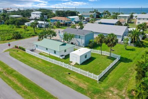 Homes with unique architectural styles and tropical ambiance, surrounded by well-maintained lawns and palm trees.