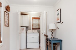 Compact laundry room with washer and dryer, functional workspace, and storage.