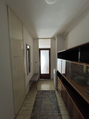 entrance leads to a cozy hallway with a kitchenette and seating area.