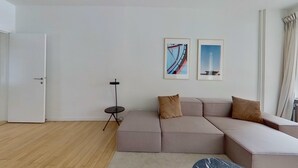 Un soggiorno moderno con un divano componibile, un tavolino e due opere d'arte incorniciate appese al muro.