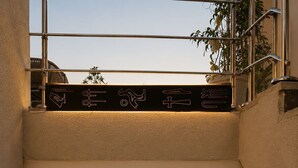 A modern interior with a staircase, a framed sculpture, and a wall-mounted light fixture. - Taj pyramids view inn (Giza)