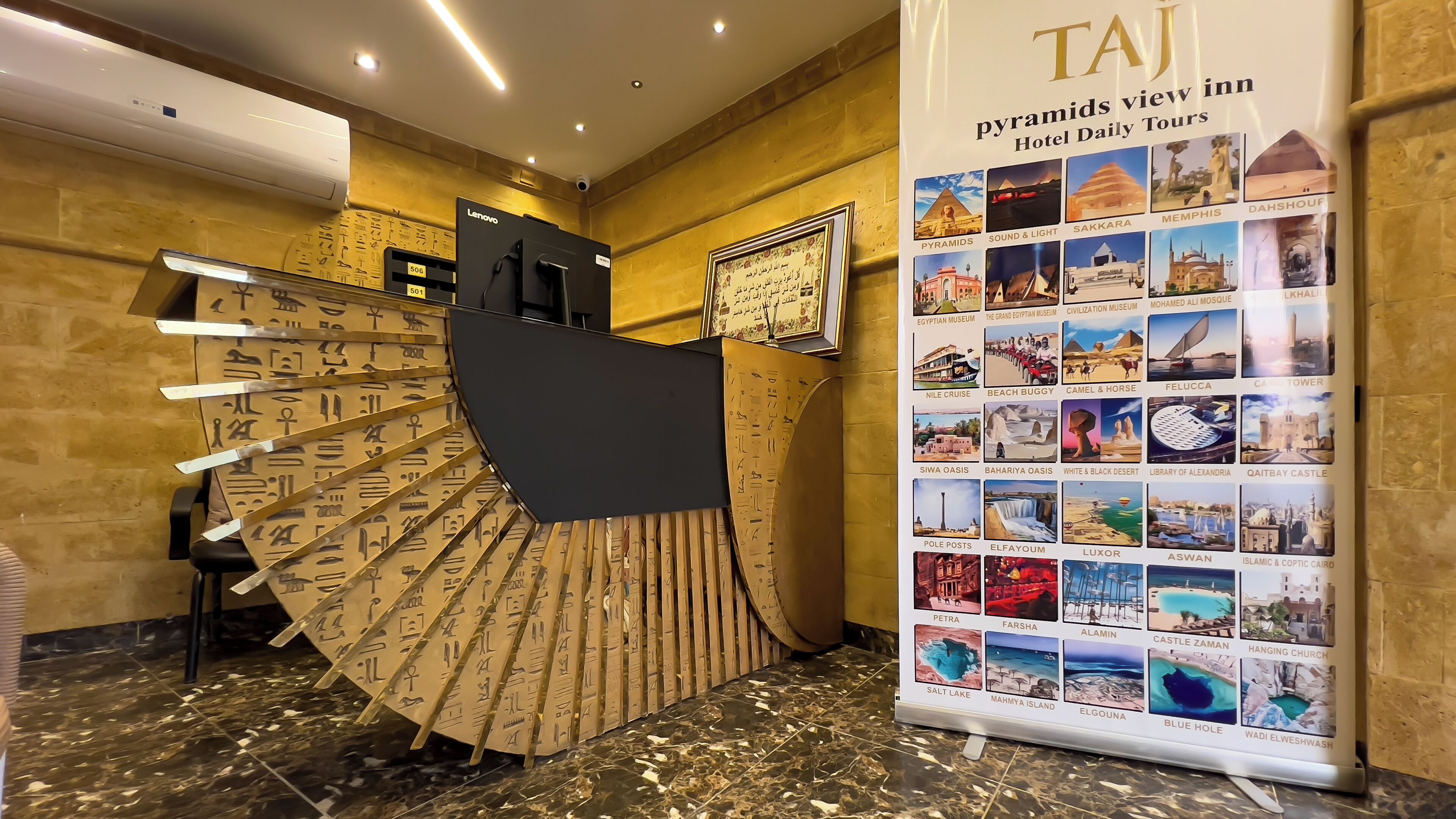 A reception desk with a large display of Egypt-themed photos and hieroglyphics.