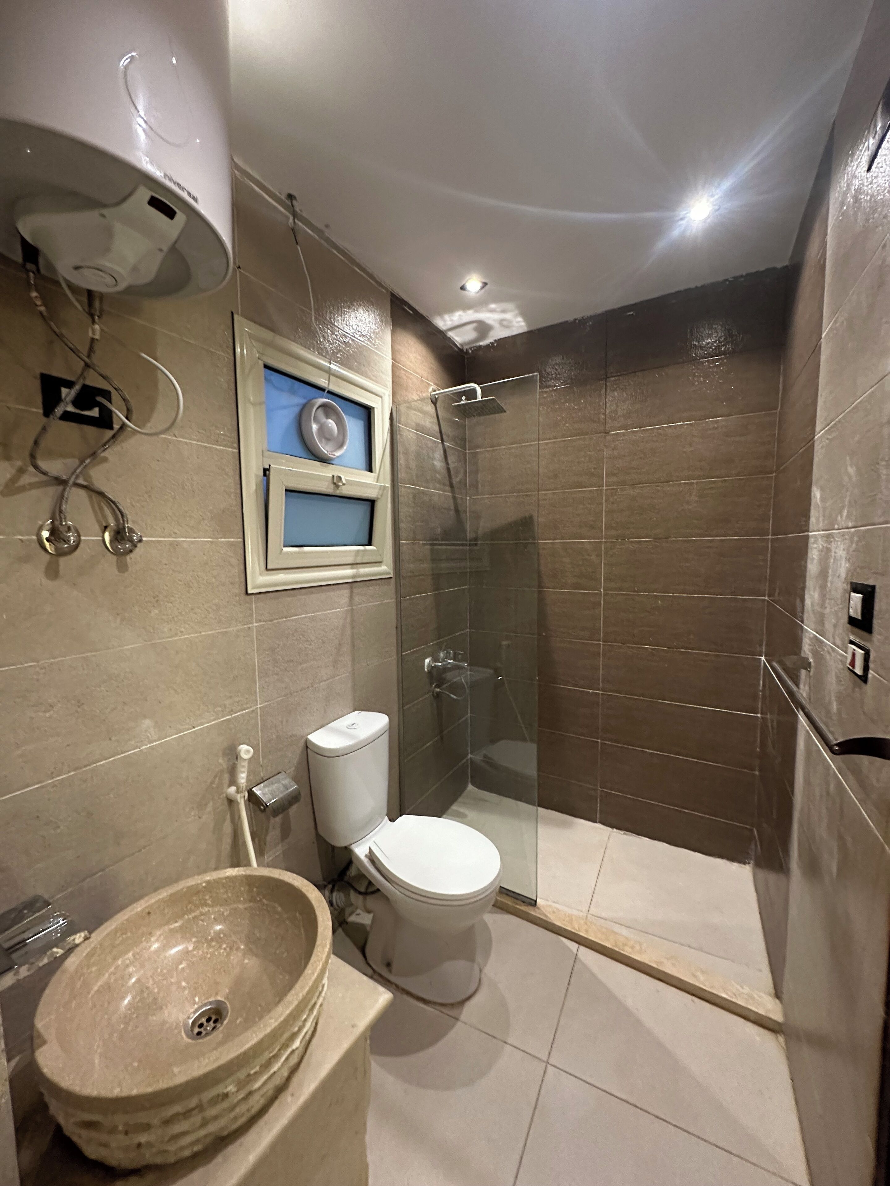 A modern bathroom with a toilet, a sink, and a glass-enclosed shower.