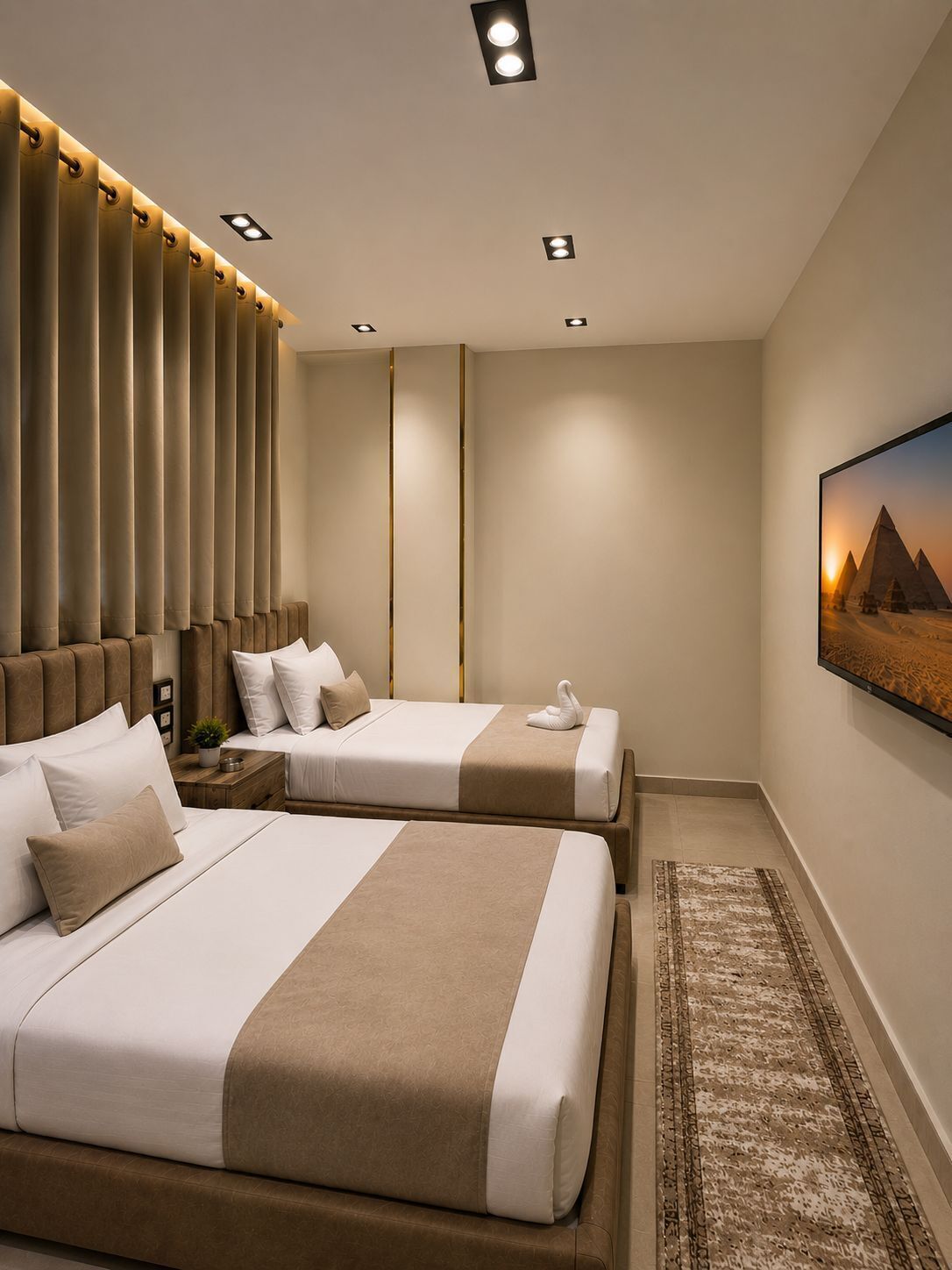 A modern hotel room with two beds, a large wall-mounted artwork of pyramids, and a patterned rug.