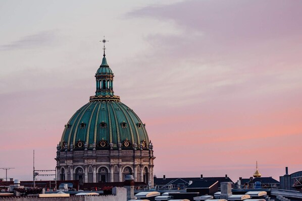 A large domed building with a spire, likely a historical or religious structure, set against a sunset sky. - Charming 1-bed in Great Frederiksberg Location (Frederiksberg)