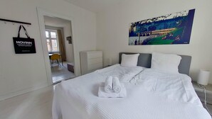 A hotel room with a bed, a painting, a desk, and a chair. - Cool 1-bed Apartment in Rhus (Aarhus)