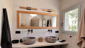 Un baño con dos lavamanos, un espejo grande y una ventana.