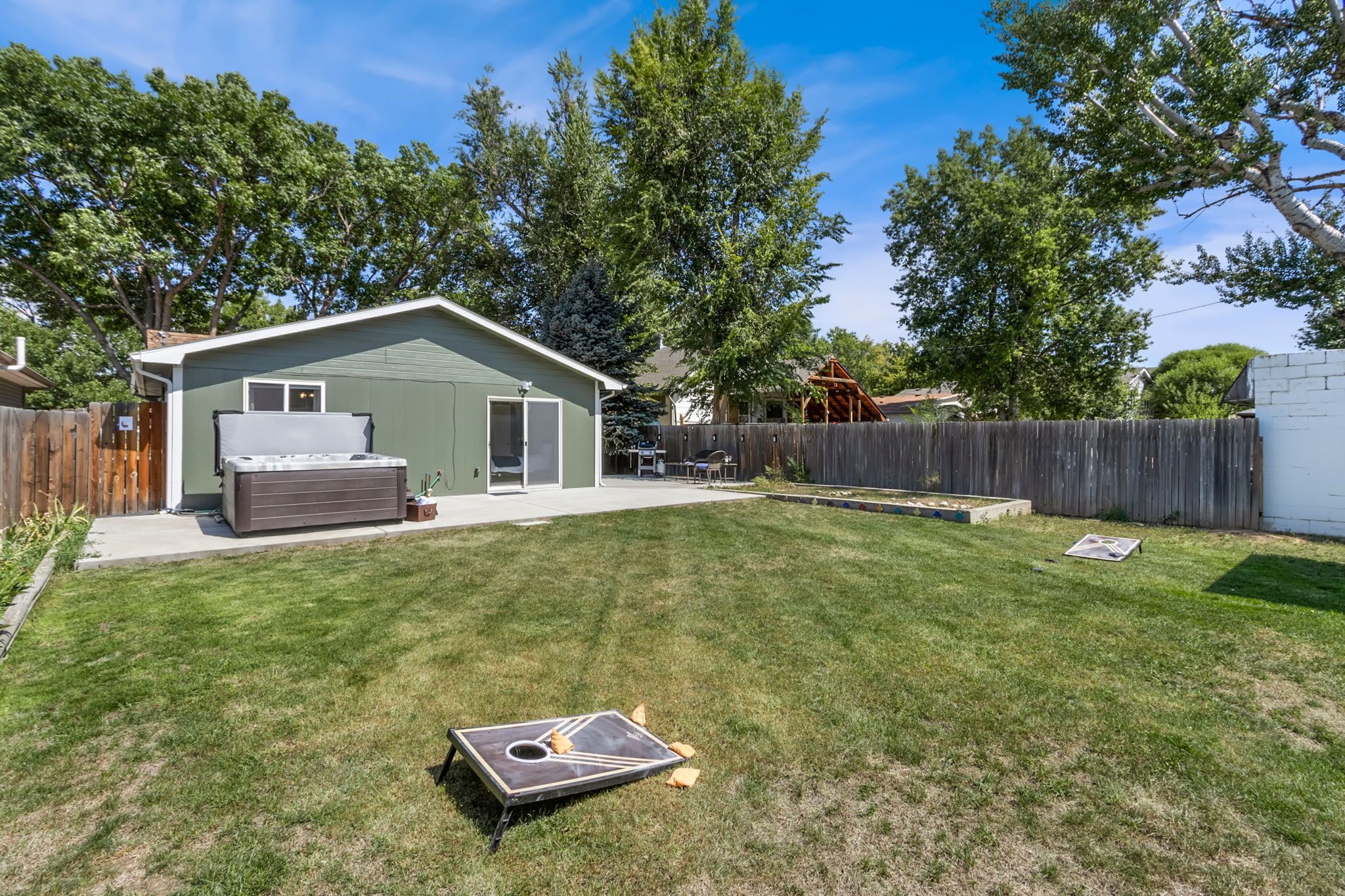 A backyard with a shed, a patio, and a wooden fence.
