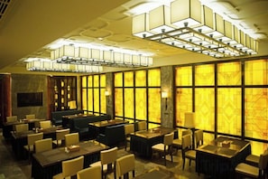 A hotel lobby with multiple seating areas, including tables and chairs, and a large chandelier. - Yiju Boutique Hotel (Yueqing)