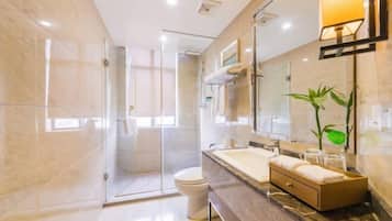 Un baño moderno con cabina de ducha de vidrio, un espejo grande y encimera de mármol.
