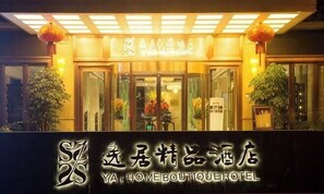 Het uiterlijk van een hotel met een bord waarop de naam in zowel Chinees als Engels staat.