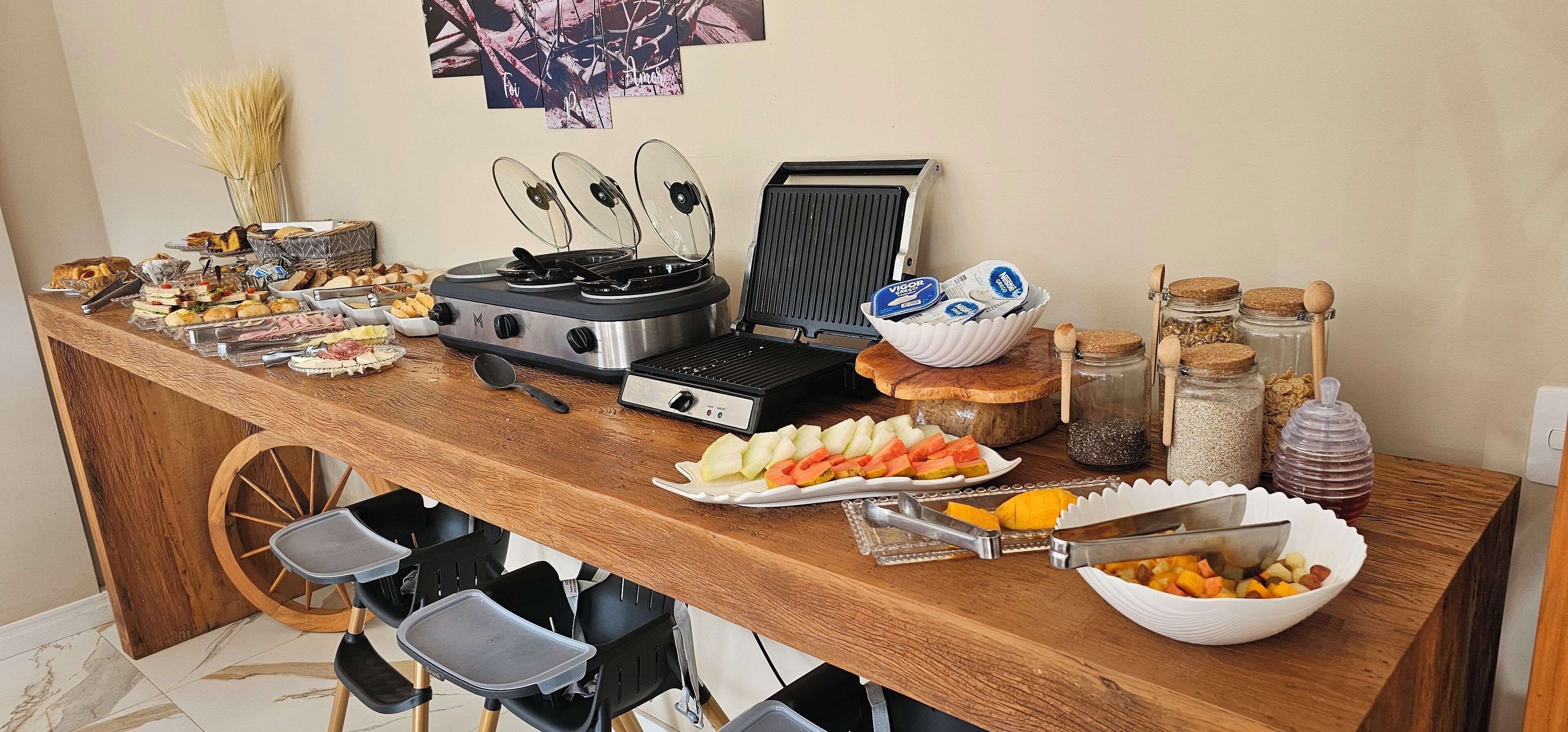 Una mesa de buffet con diversos alimentos, una estufa portátil y condimentos.