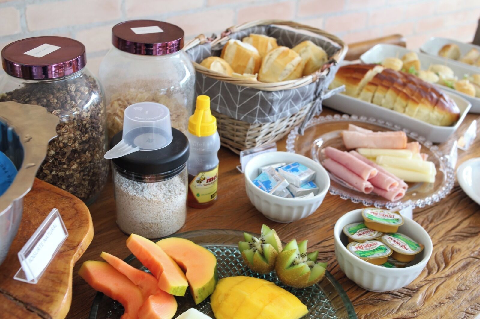 A table with various food items including bread, pastries, cheese, and fruits.